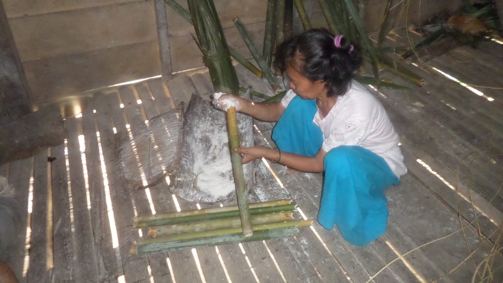 Filling the bamboo with sago flour